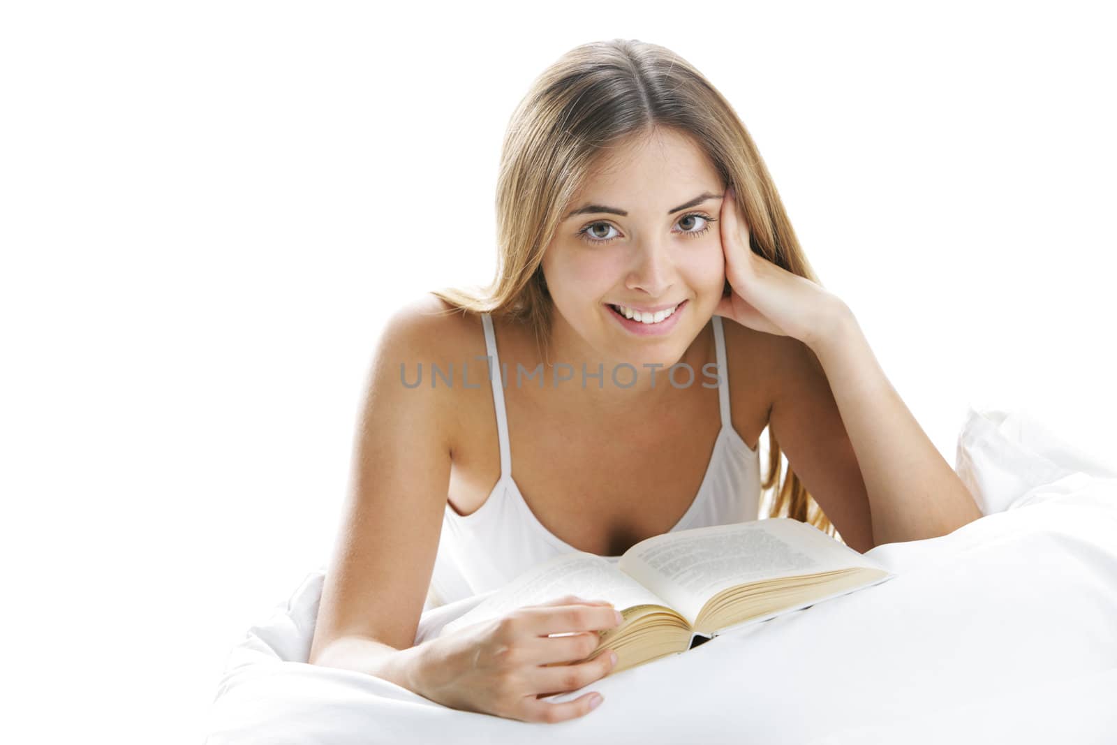 Young smiling woman reading in bed