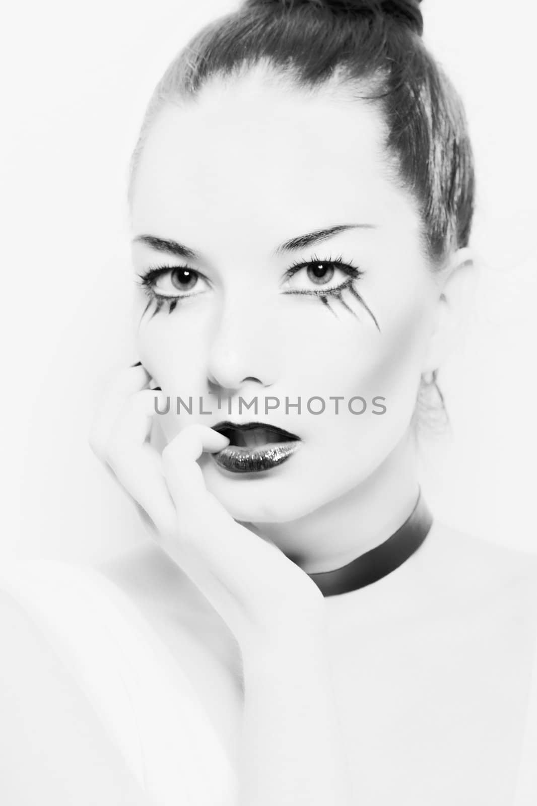 monochrome portrait of a girl with dark make-up on a white background.