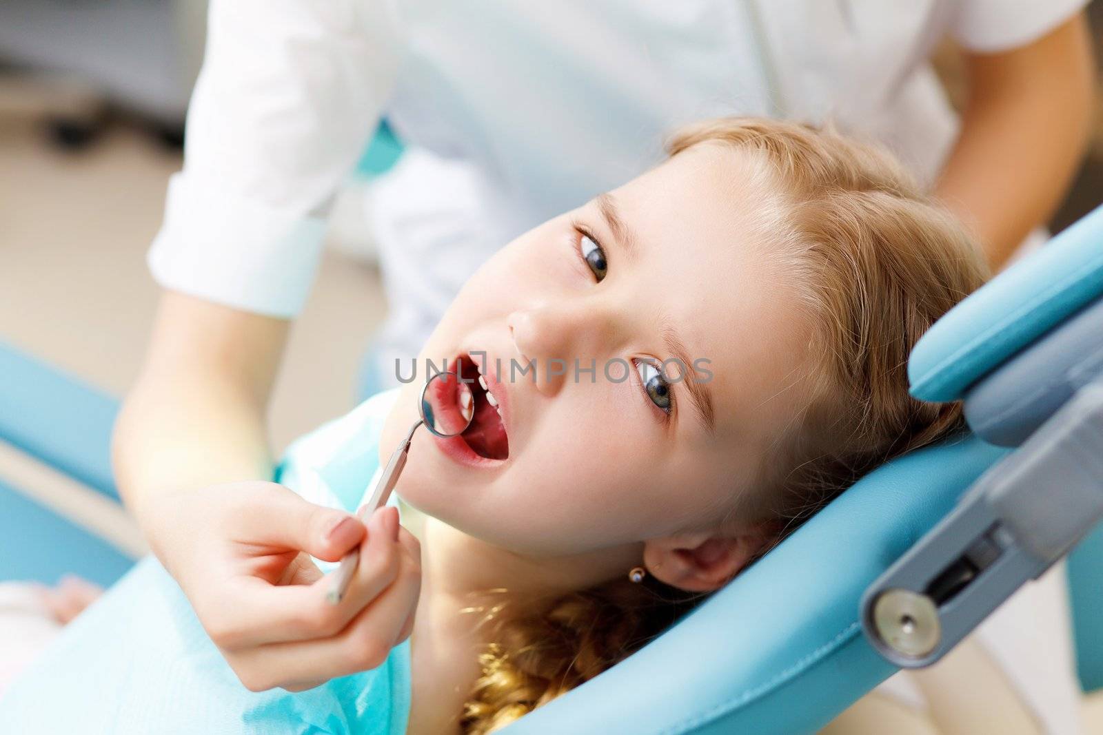 Little girl sitting in the dentists office