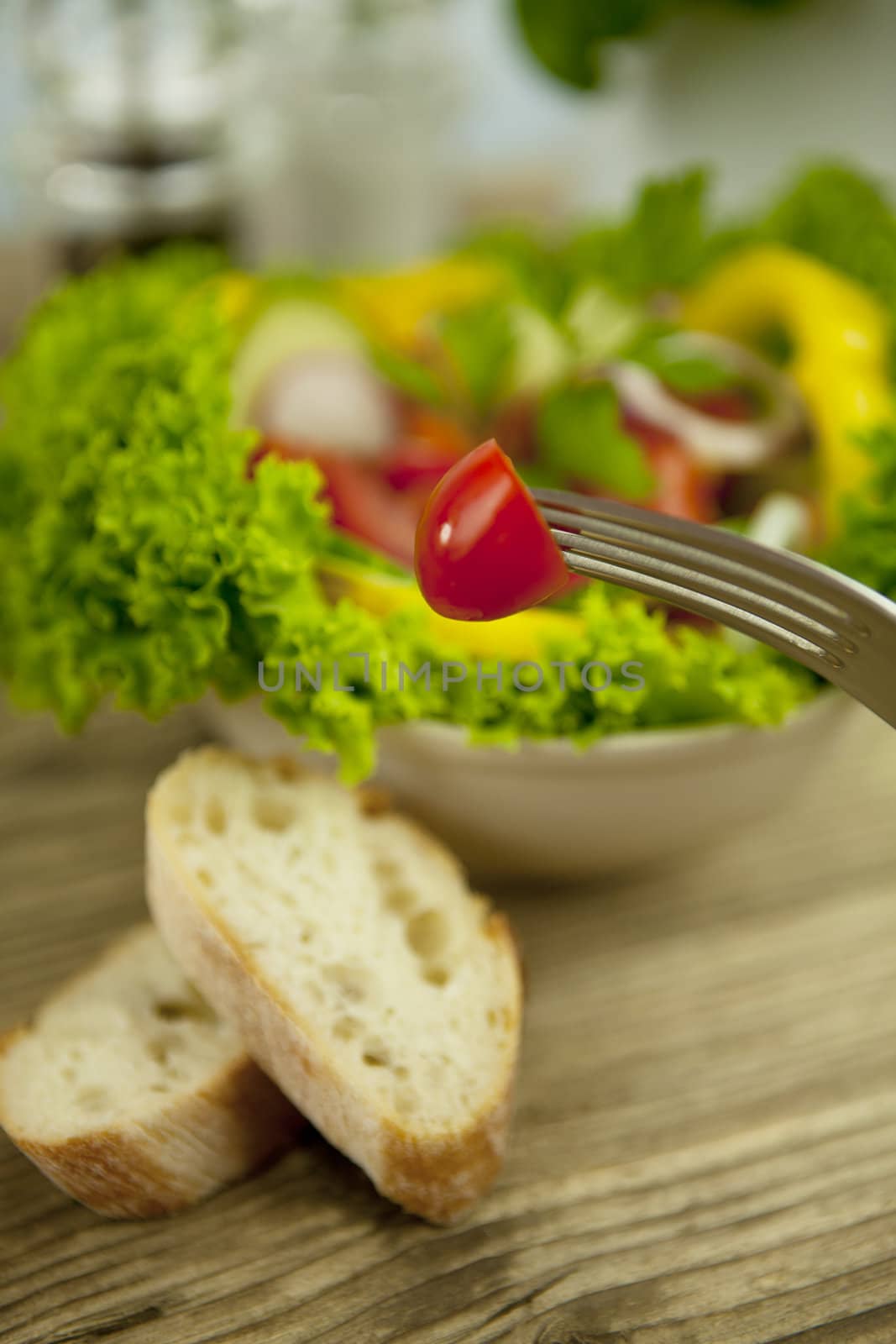 fresh tasty healthy mixed salad and bread on wooden table