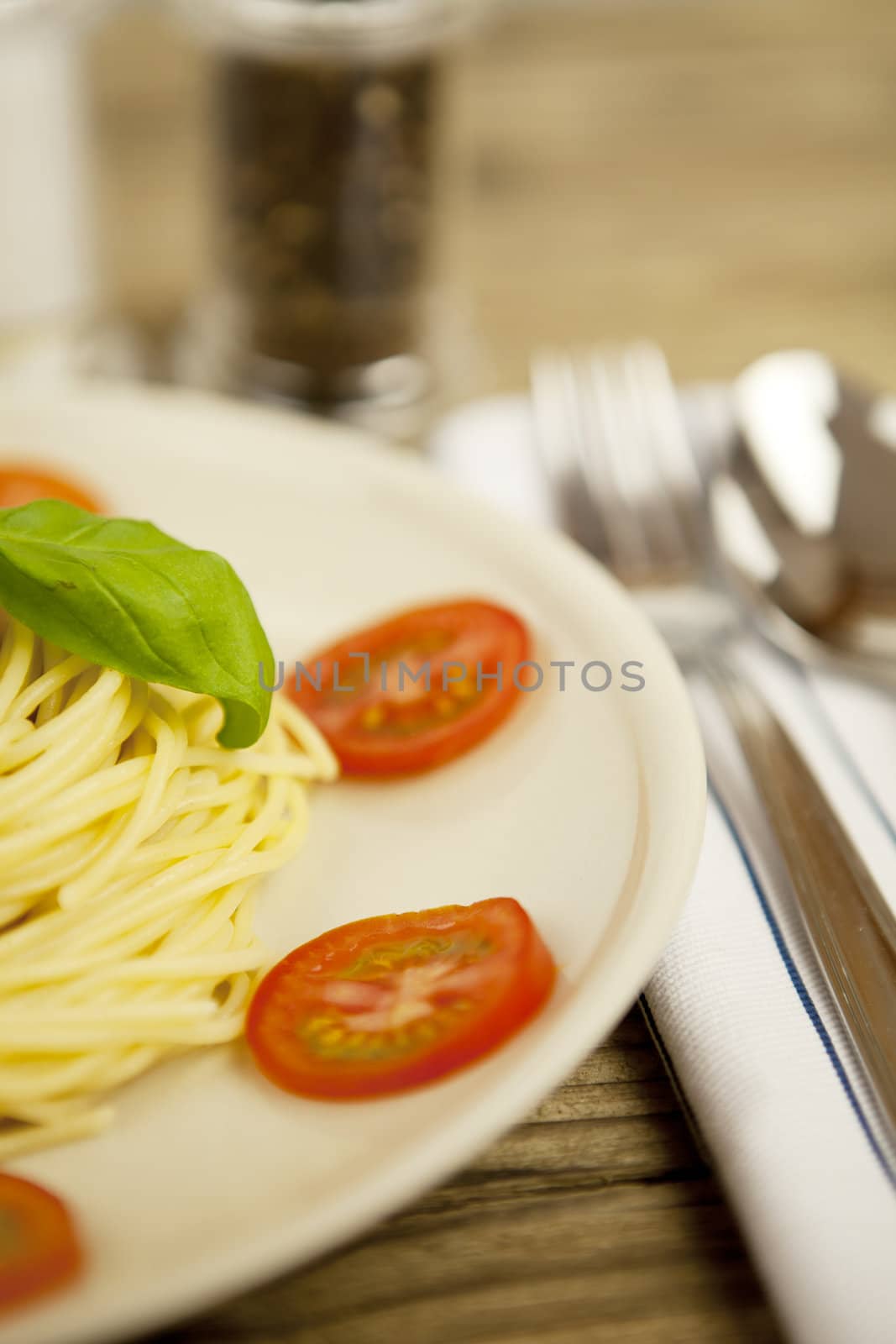 fresh tasty pasta with tomato and basil on wooden table