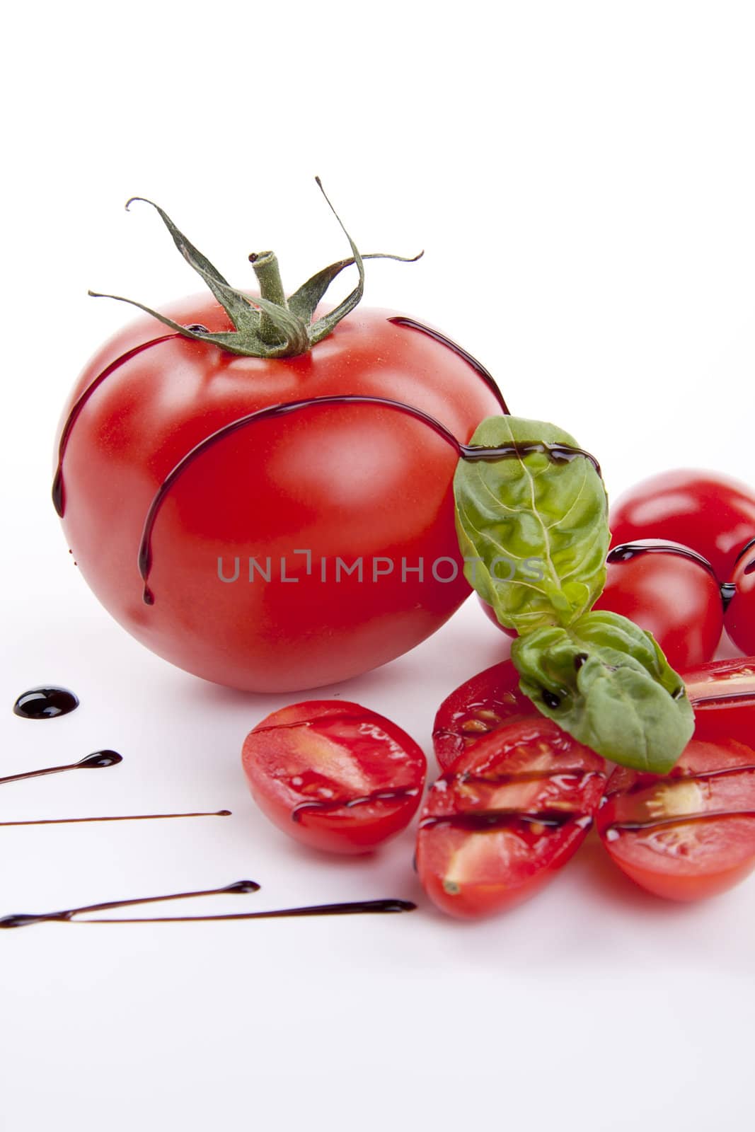 fresh red tomatoes with balsamic and oilve oil isolated on white background