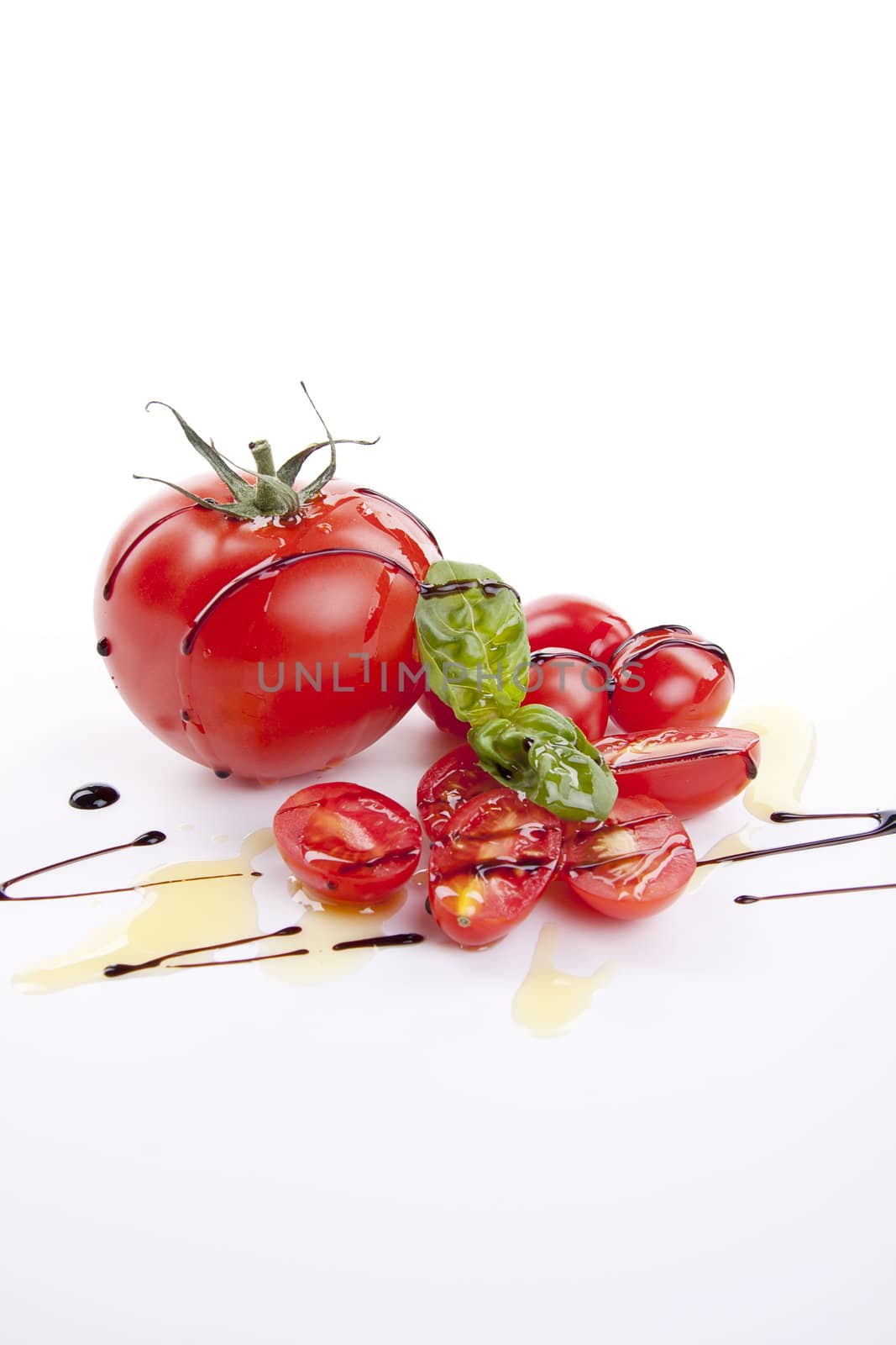 fresh red tomatoes with balsamic and oilve oil isolated on white background
