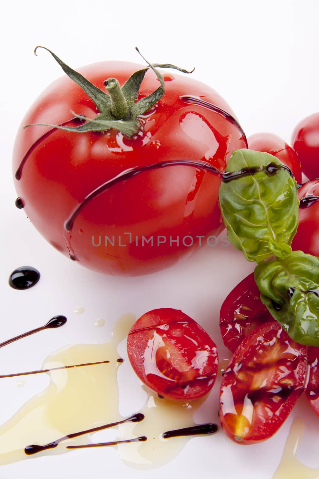 fresh red tomatoes with balsamic and oilve oil isolated on white background