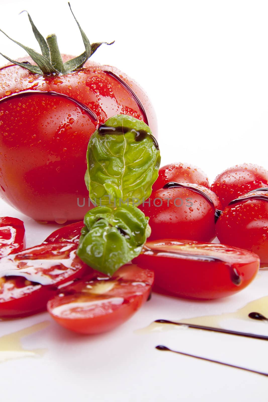 fresh red tomatoes with balsamic and oilve oil isolated on white background