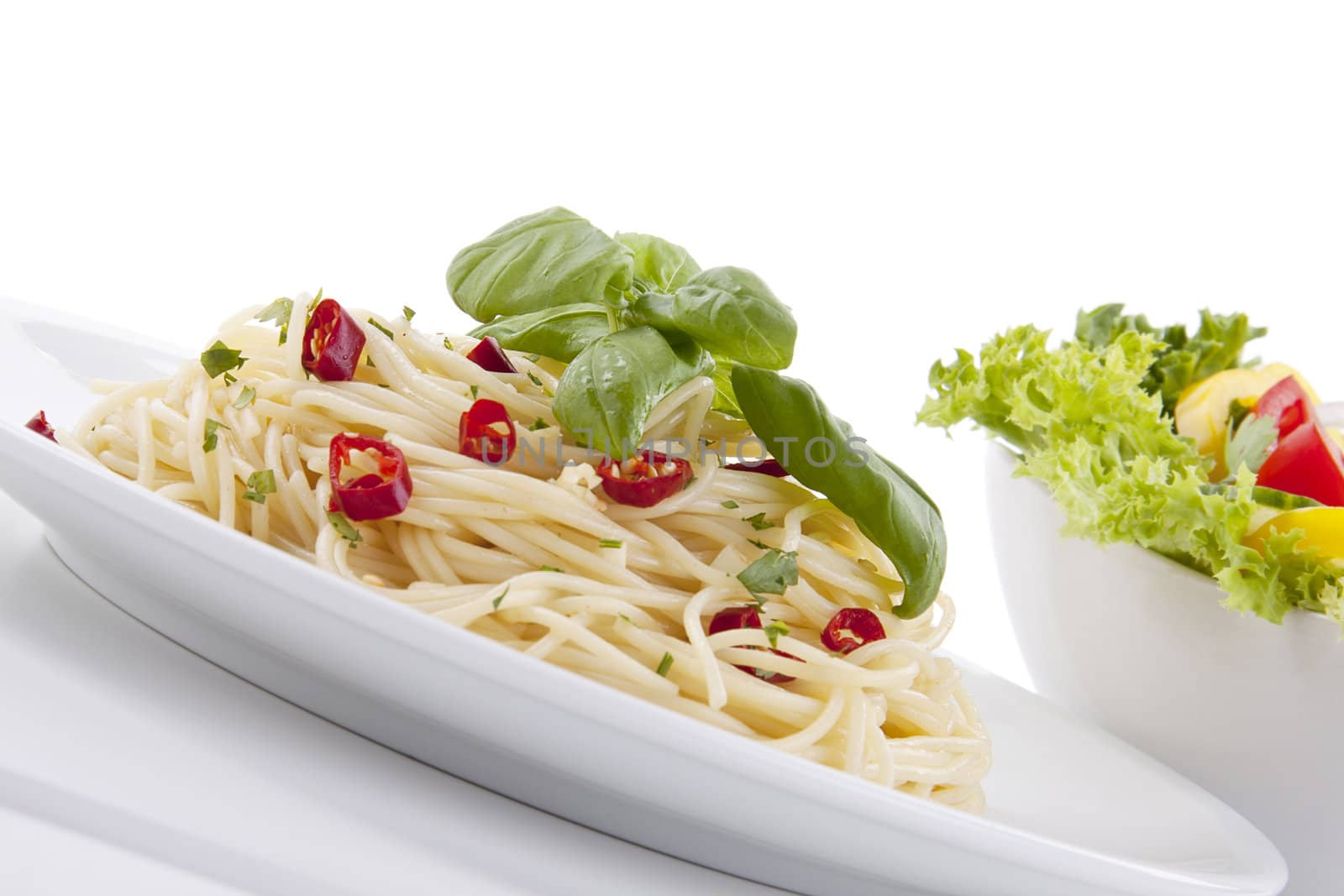 fresh pasta with chilli and basil with salad isolated on white background