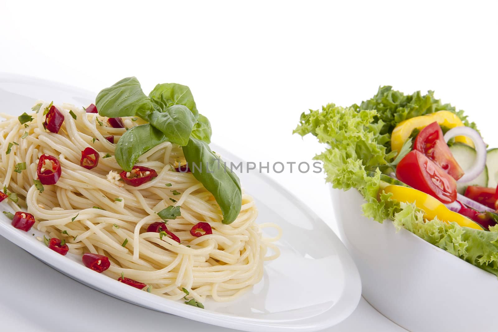 fresh pasta with chilli and basil with salad isolated on white background