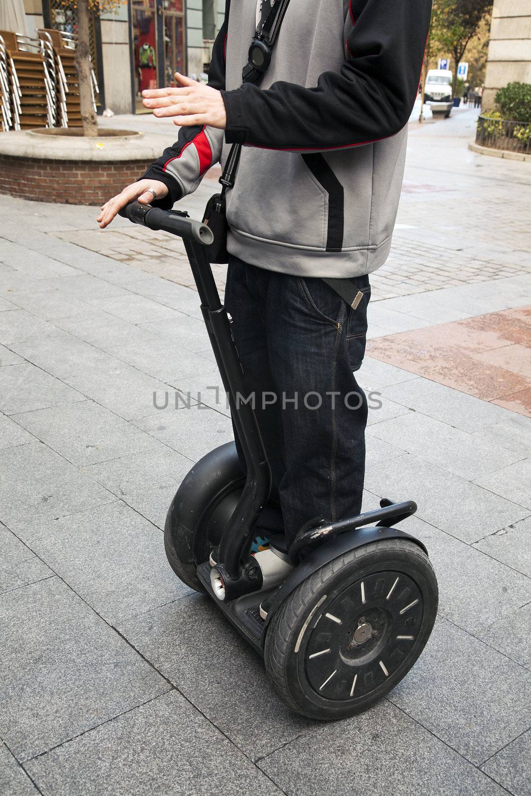 A man denstrates how to ride a Segway in the street.