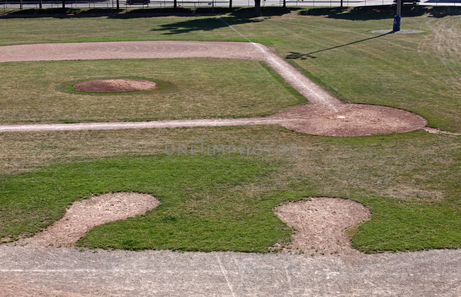 An unoccupied baseball field featuring on deck circles, shot from the bleachers.
