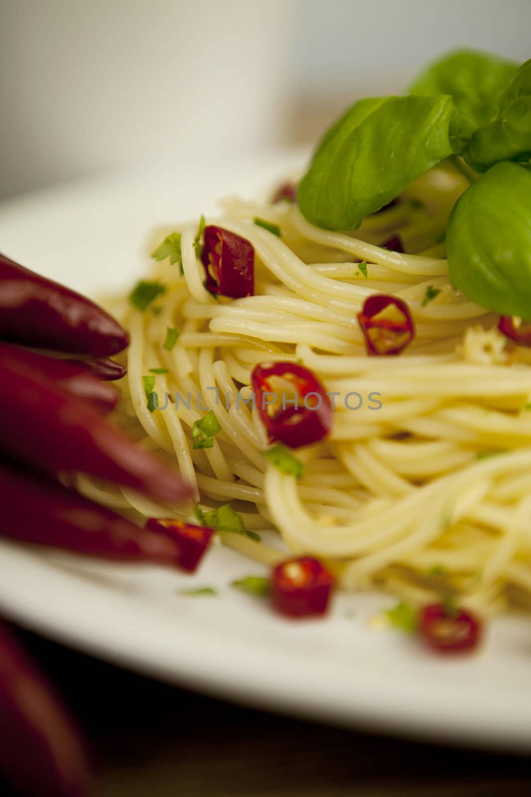 fresh pasta with basil and red chilli on wooden table