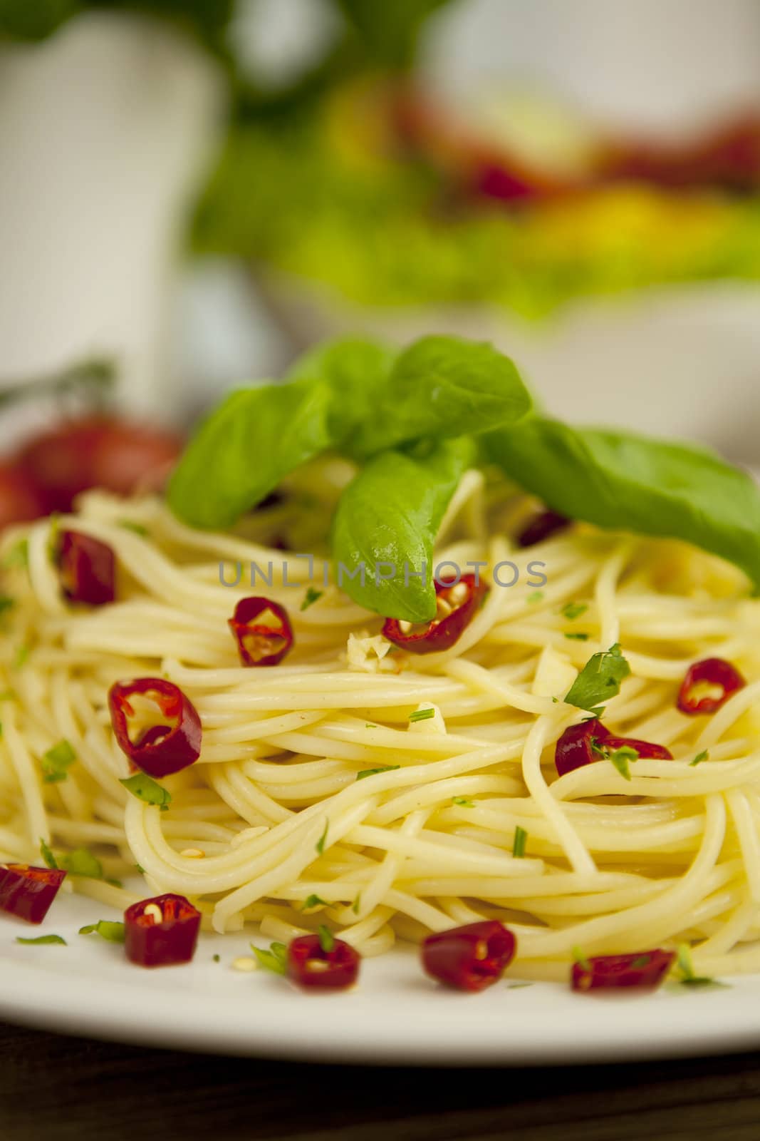 fresh pasta with basil and red chilli on wooden table