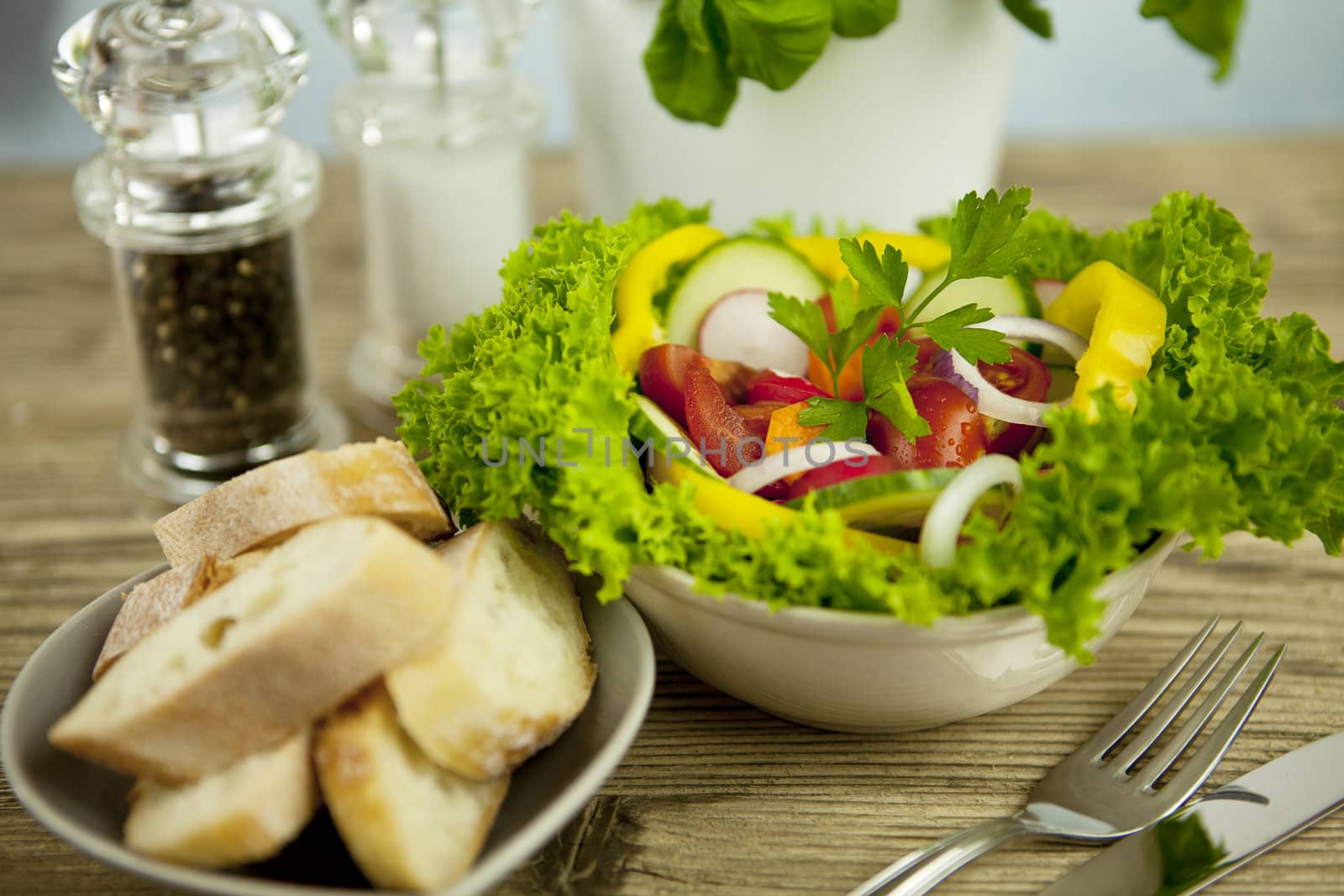 fresh tasty healthy mixed salad and bread on wooden table