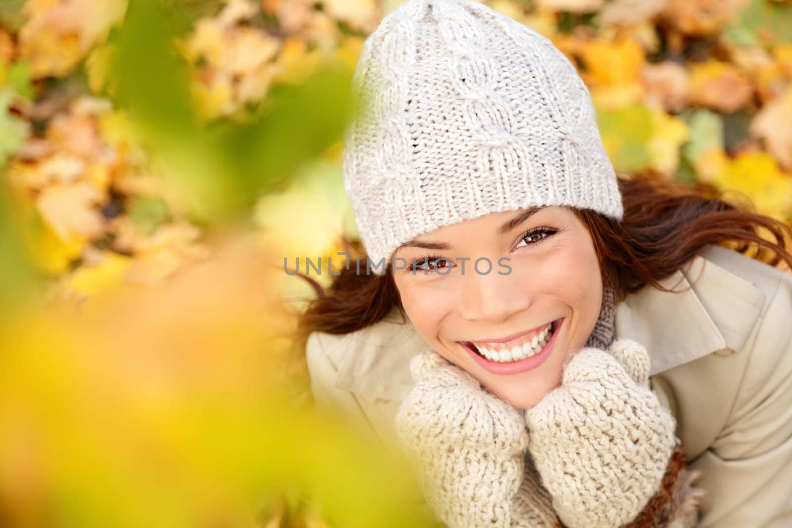Autumn woman in yellow leaves portrait. utumn portrait of happy lovely and beautiful mixed race Asian Caucasian young woman in forest in fall colors.