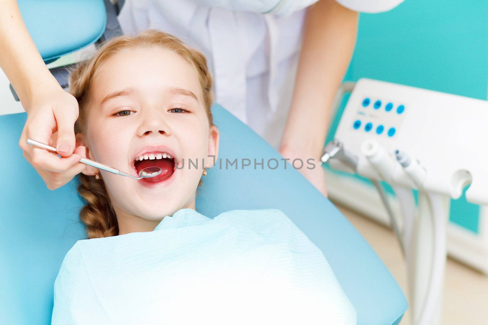 Little girl sitting in the dentists office