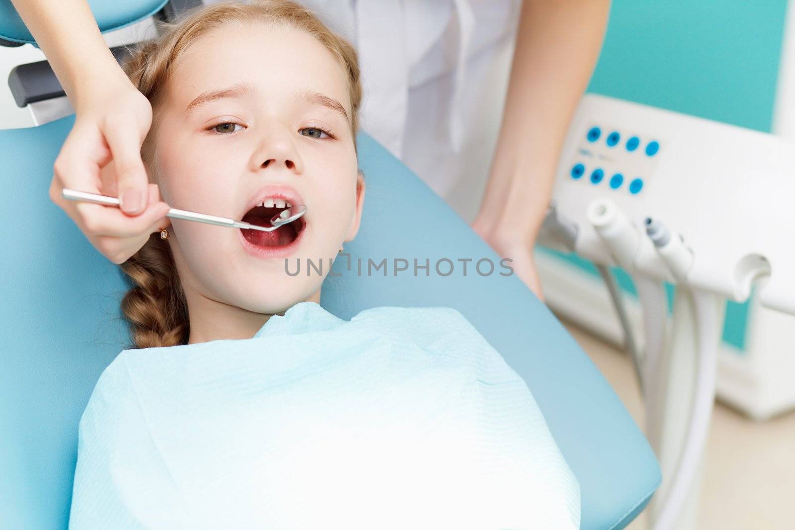 Little girl sitting in the dentists office