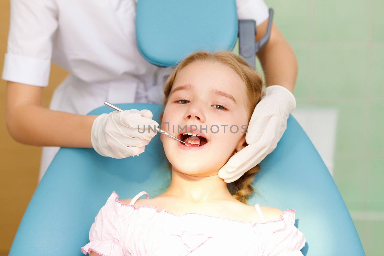 Little girl sitting in the dentists office