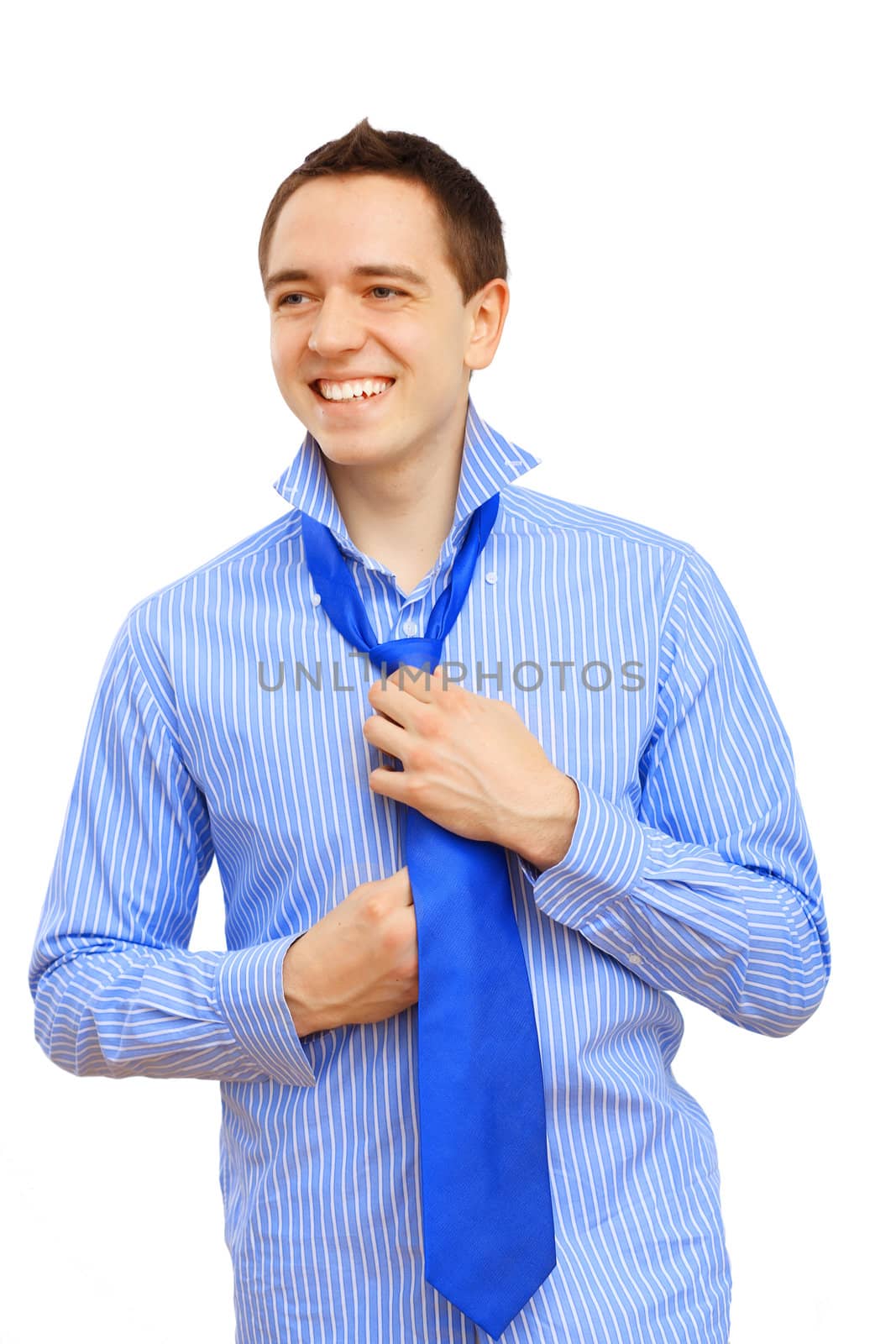 Attractive young business man binding his blue tie