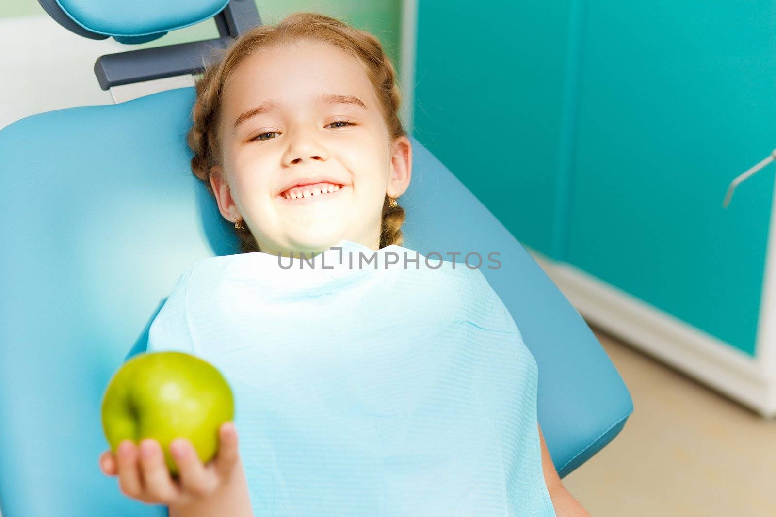 Little girl sitting in the dentists office