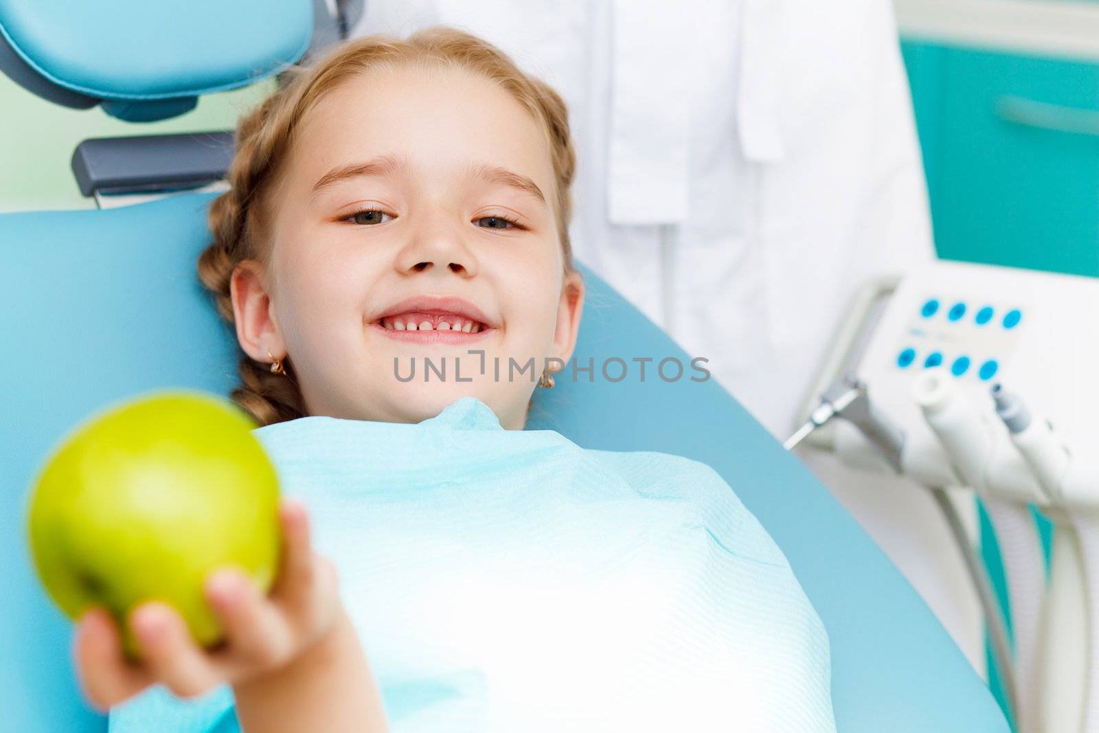 Little girl sitting in the dentists office