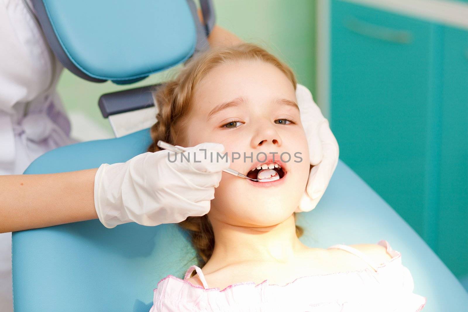 Little girl sitting in the dentists office