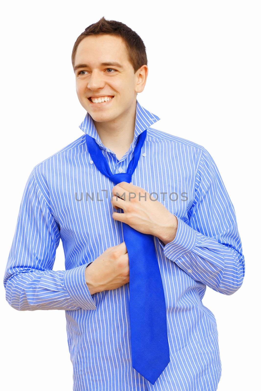 Young businessman at home preparing for a work and making his tie