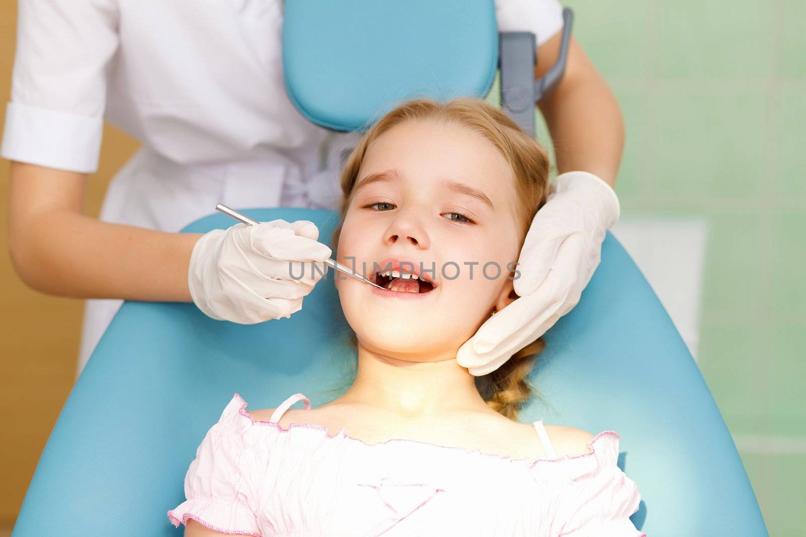 Little girl sitting in the dentists office