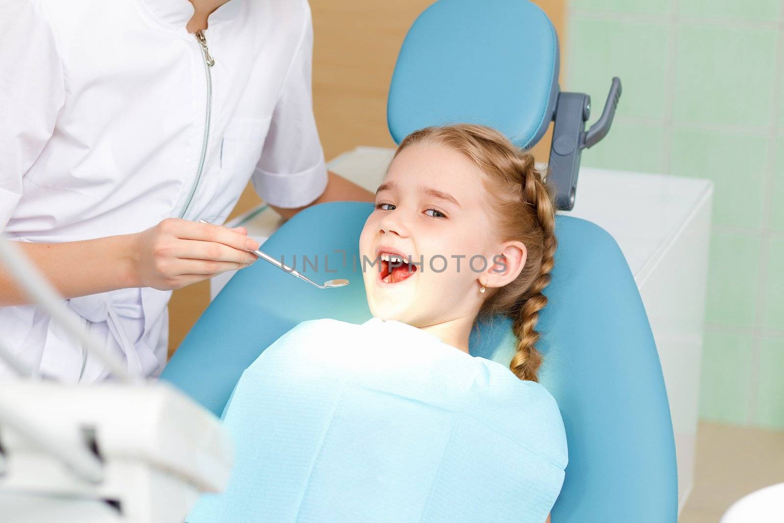 Little girl sitting in the dentists office