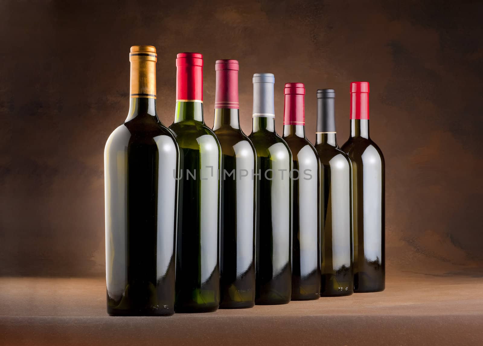 Red wine bottles in a row with empty labels on a mottled canvas background