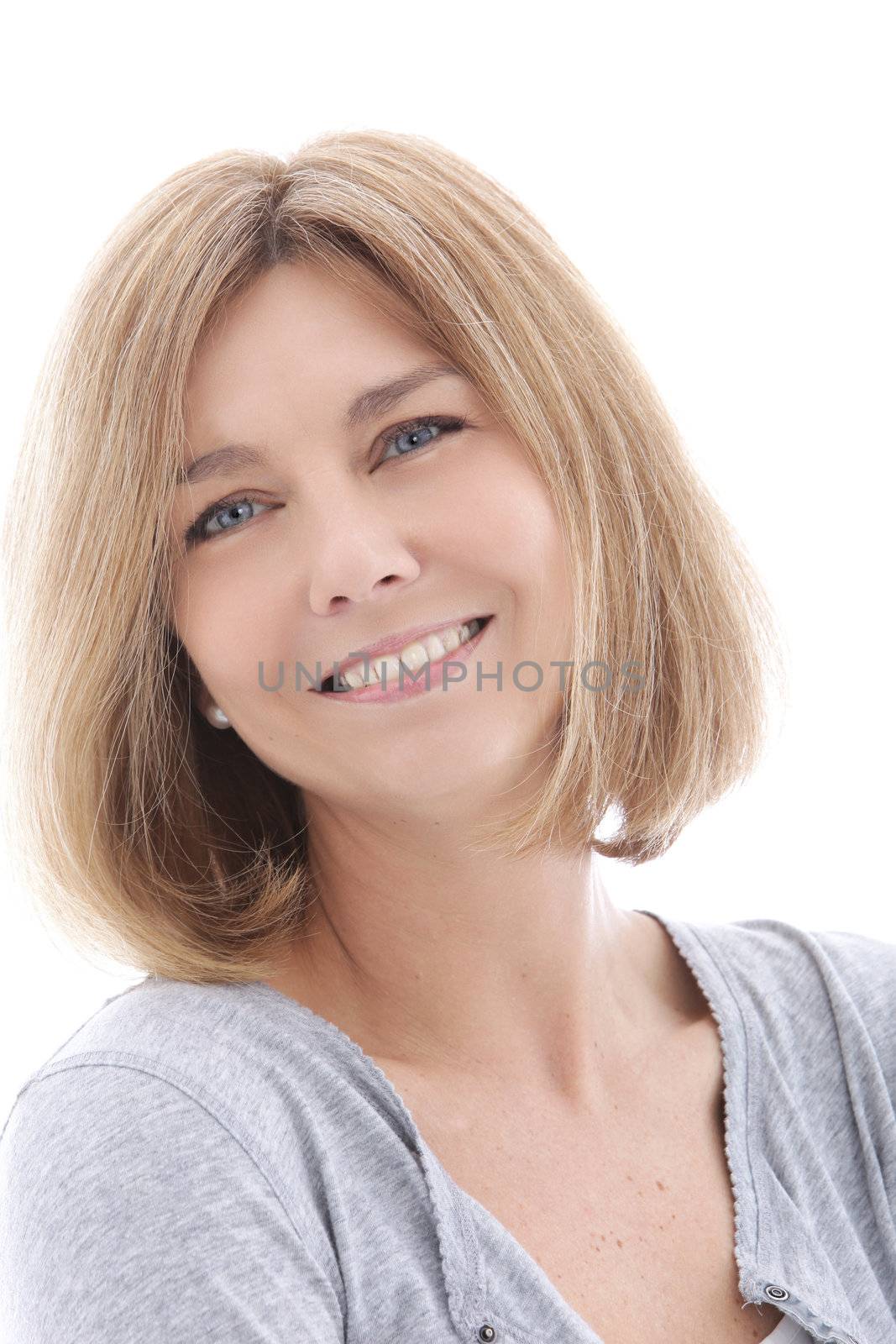 Happy middle-aged woman smiling and looking at the camera, head and shoulders studio portrait on white