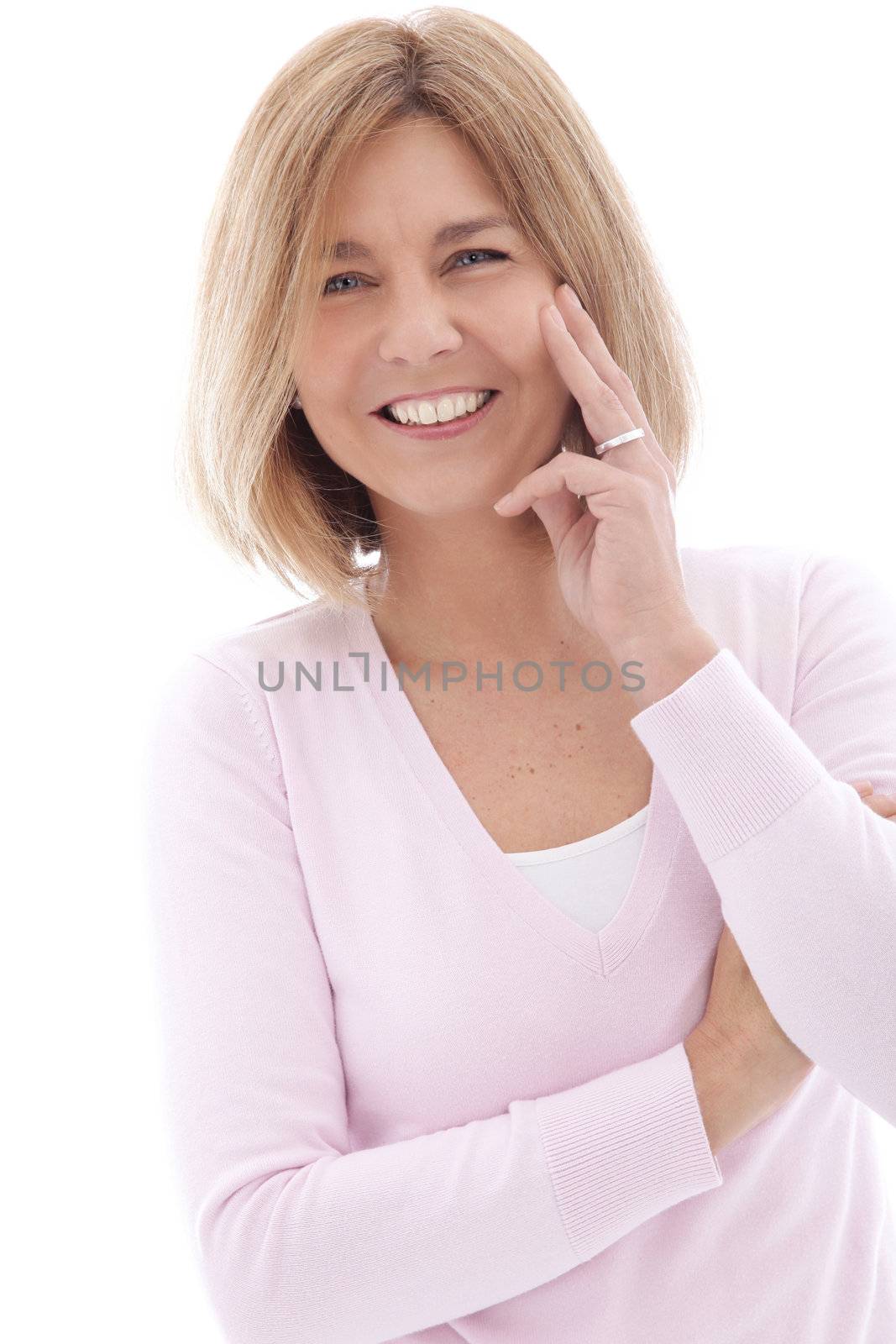 Attractive mature woman with a lively smile holding her hand to her cheek looking at the camera, upper body portrait isolated on white