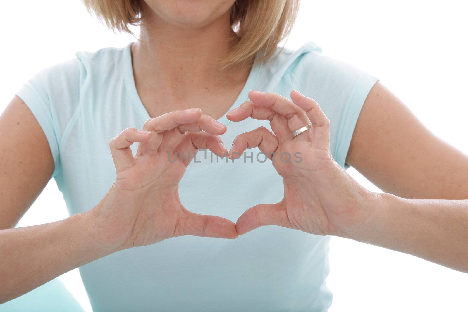 Woman making a heart gesture with her fingers in front of her chest, closeup cropped torso view of her hands