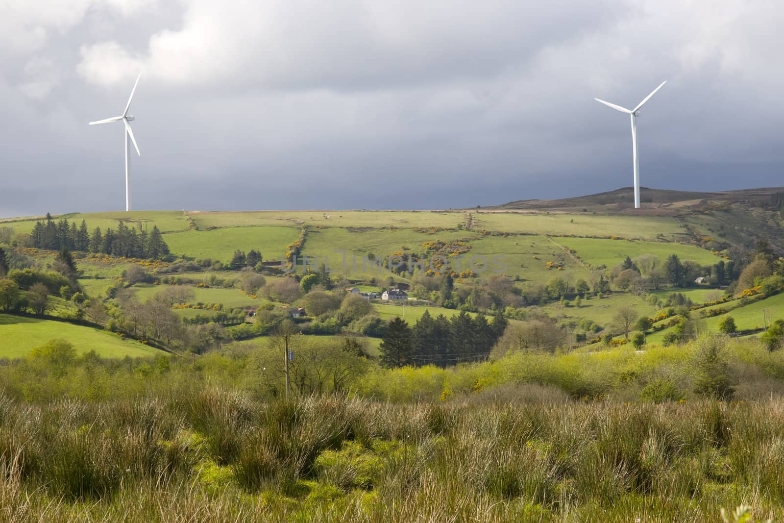 windmills on the hills of Glenough in county Tipperary Ireland with trees and fields in foreground