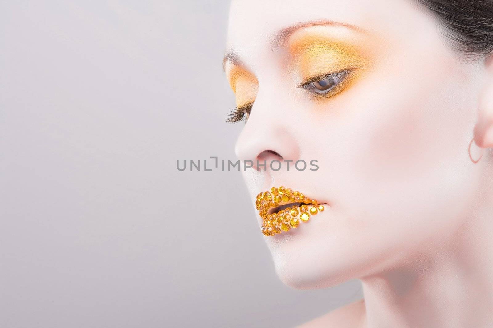 Young caucasian woman with gold fashion makeup by hangingpixels