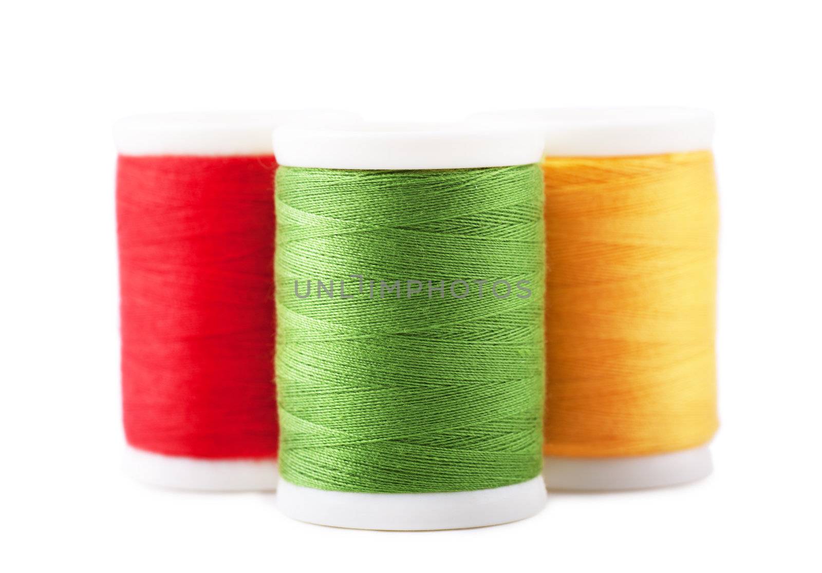 Three spools with green, red and yellow thread