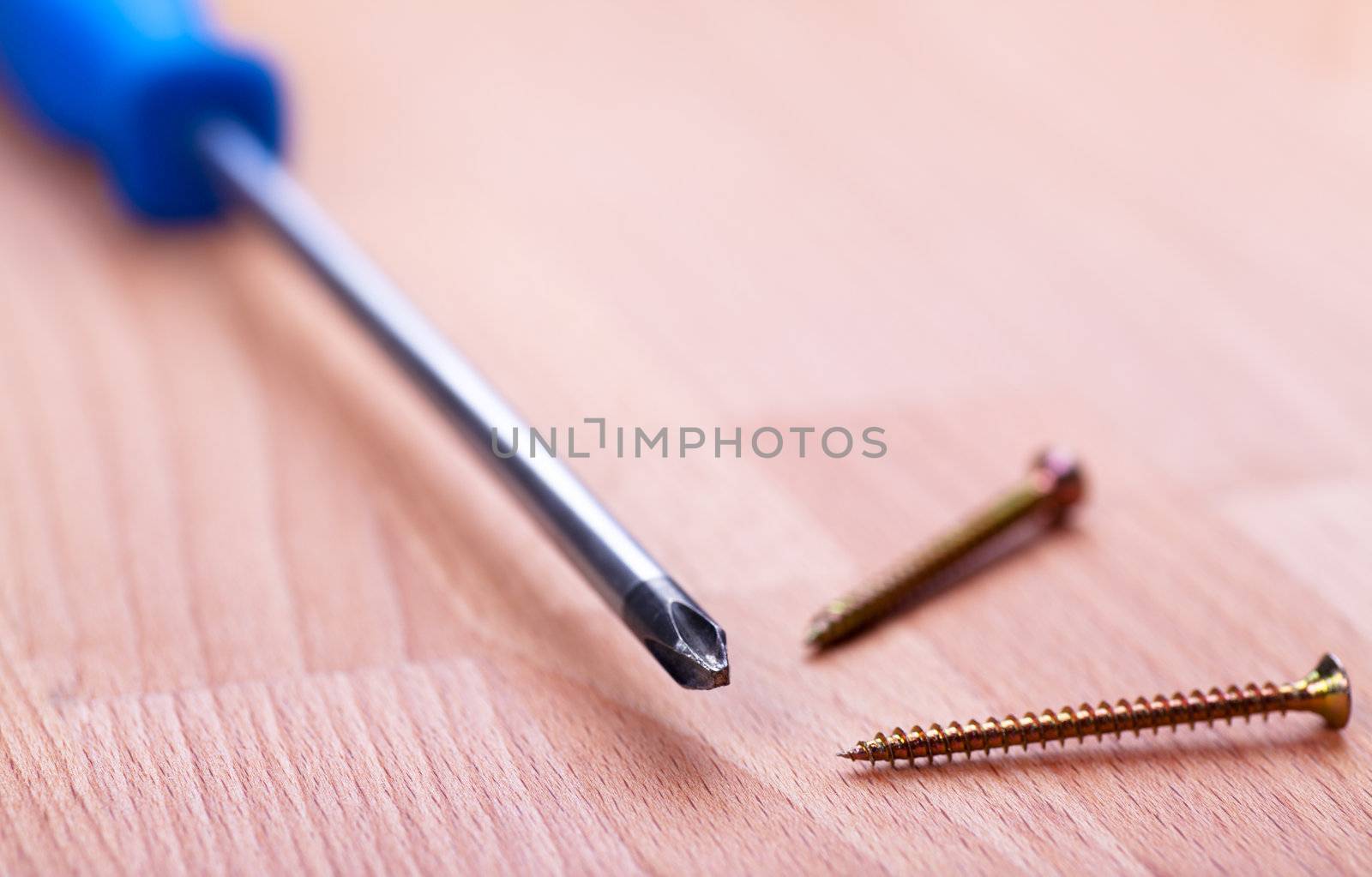 Closeup view of screwdriver over wood background
