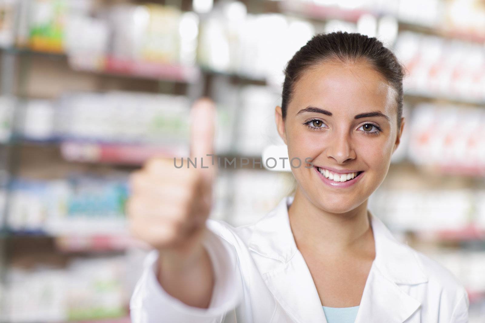 Smiling young woman phamrmacist giving thumbs up