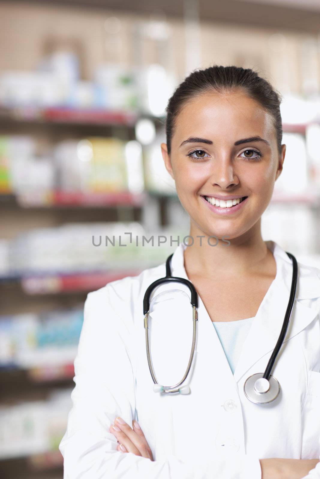 Portrait of Smiling Woman Pharmacist in Pharmacy by stokkete