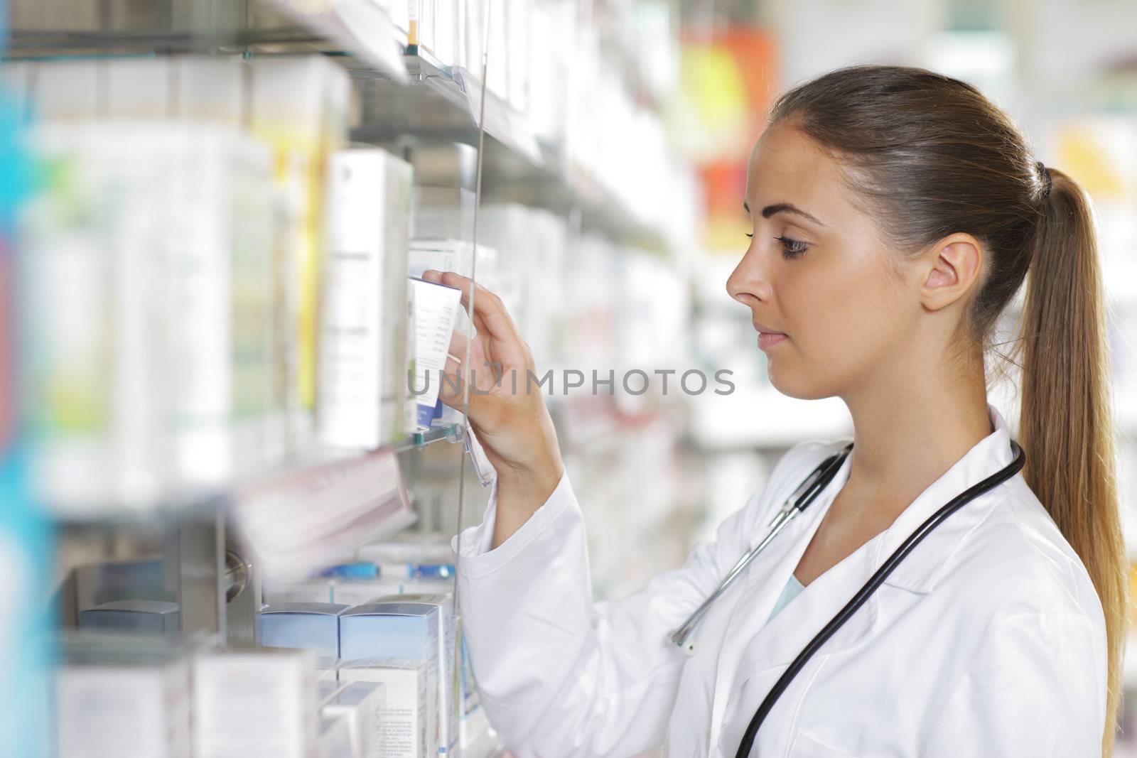 Portrait of a young female pharmacist selecting a medication