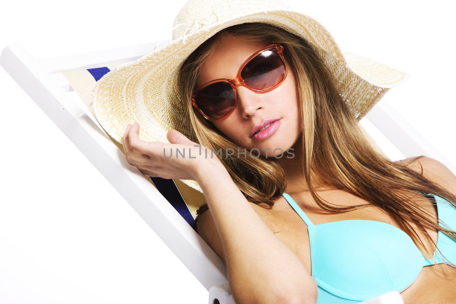Beautiful young woman relaxing on beach chair, isolated on white background