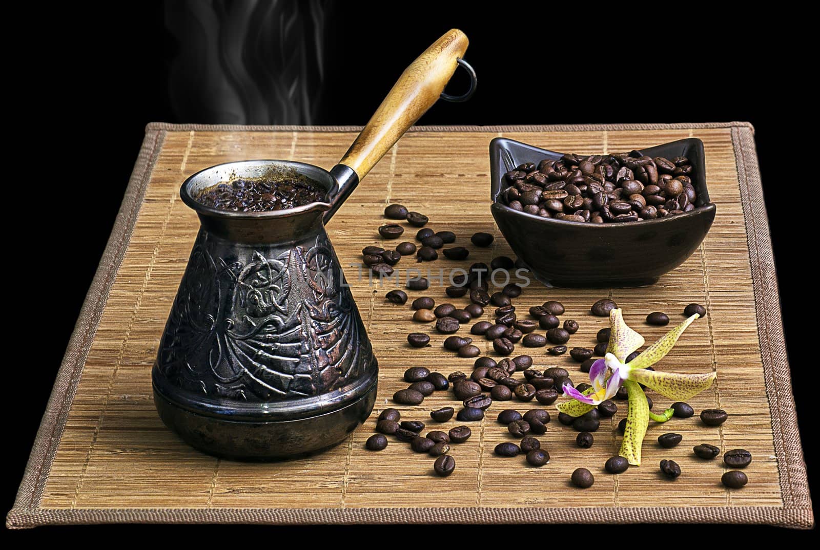 Coffee turk with coffee beans and orchid on black background isolated.