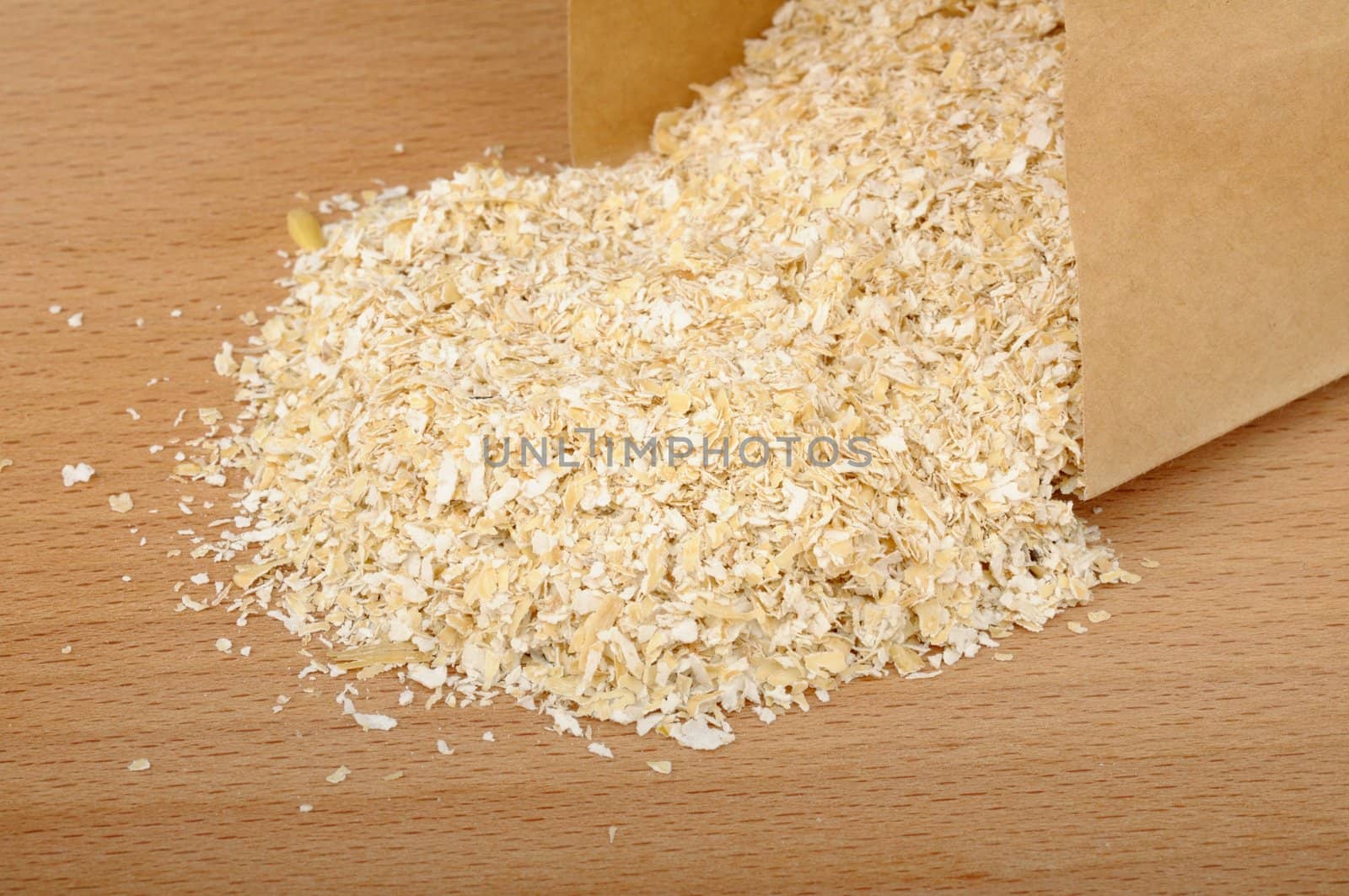 oat bran in a paper bag on a wooden background