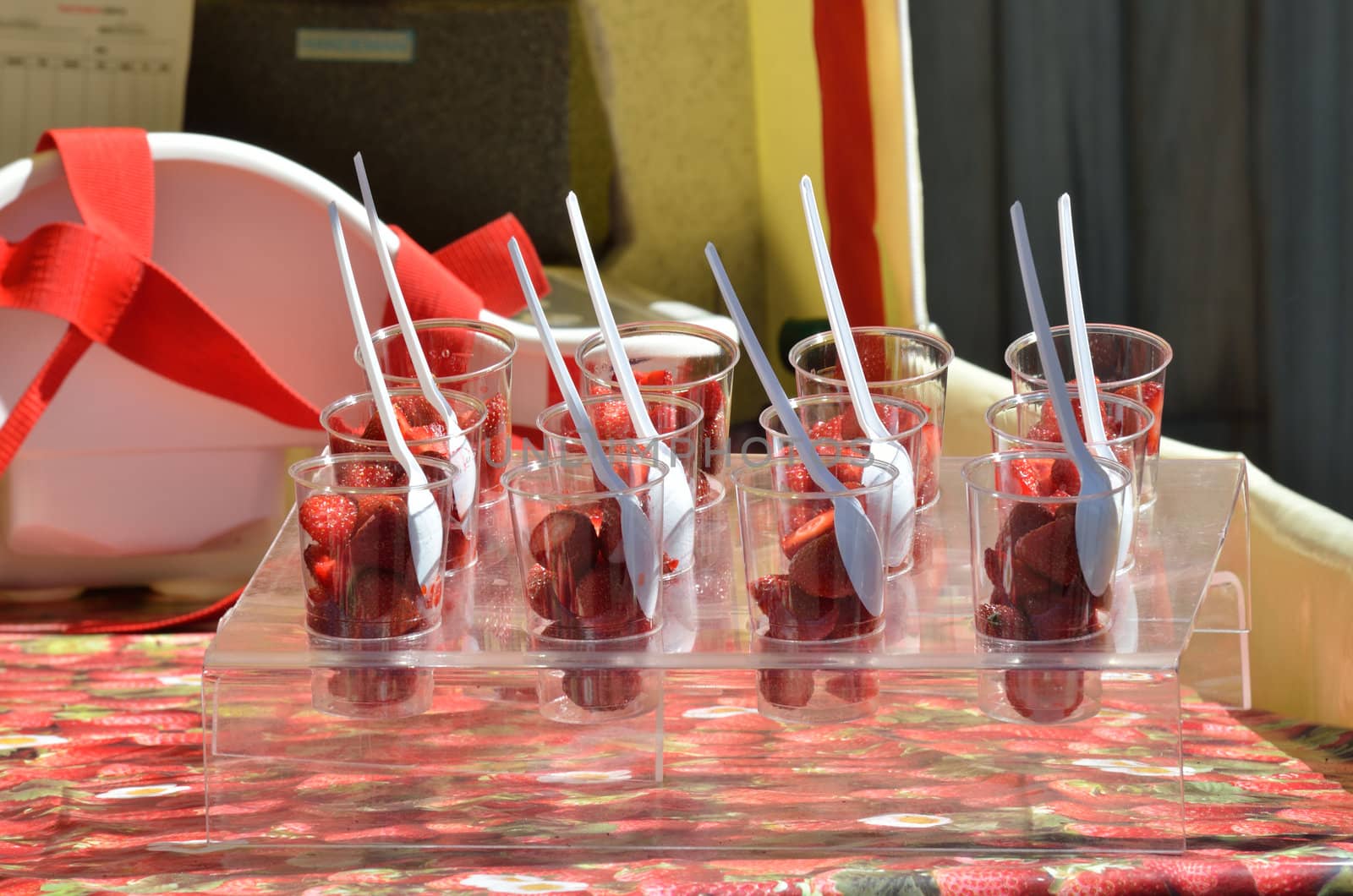 Strawberries in plastic cups with spoons
