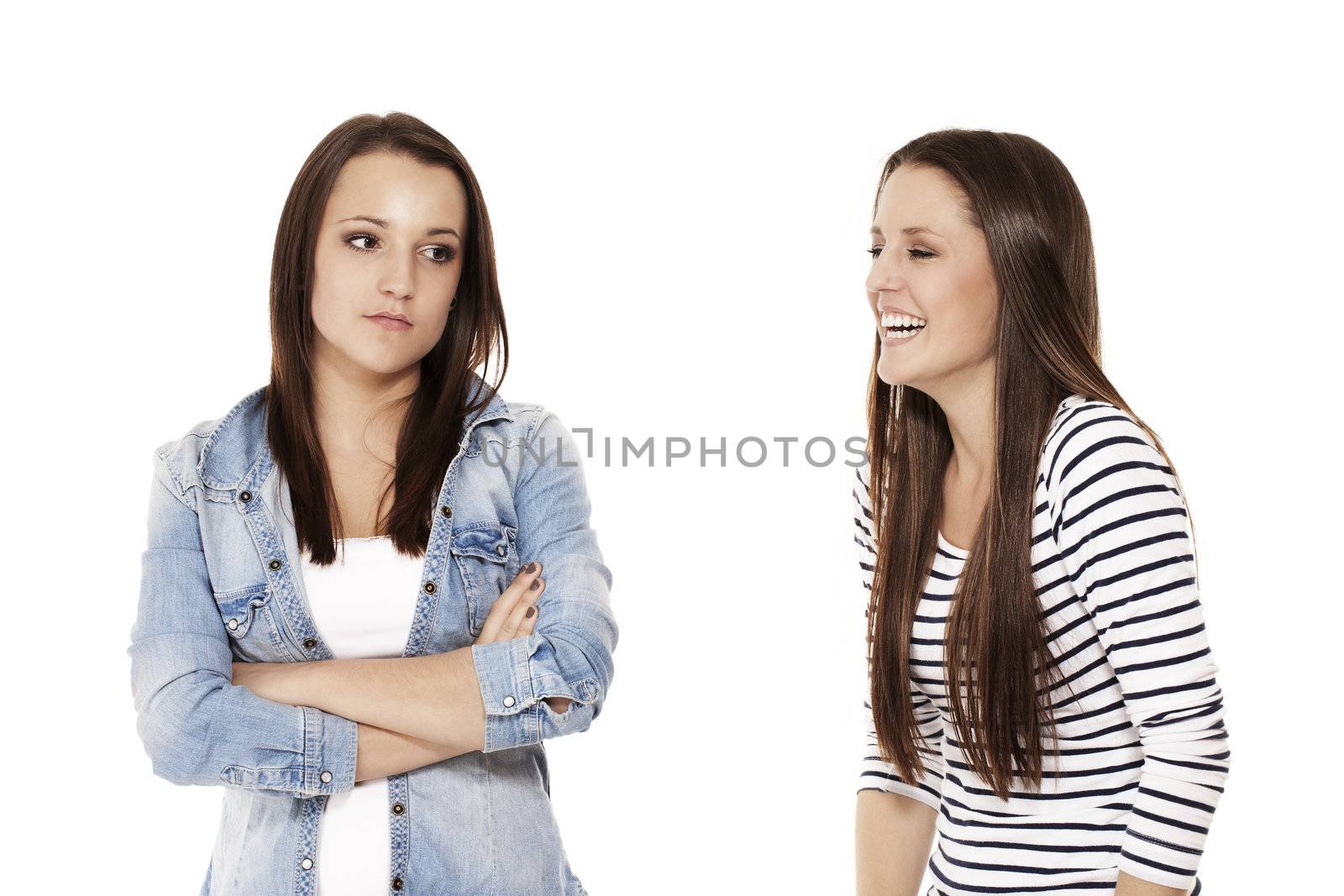 teenager laughing at her upset sister on white background