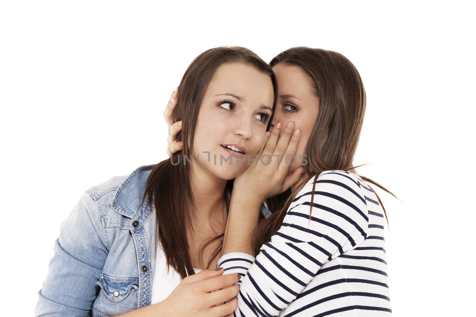 teenager whispering news to her sister on white background