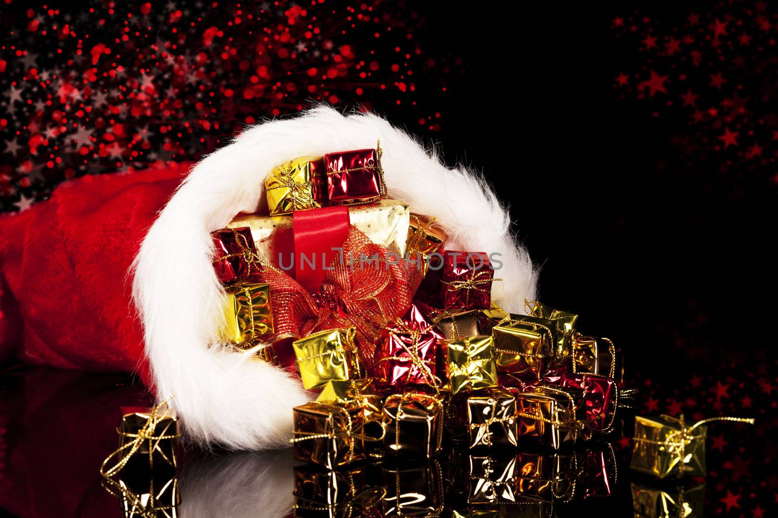 christmas presents falling from santa's hat on black background