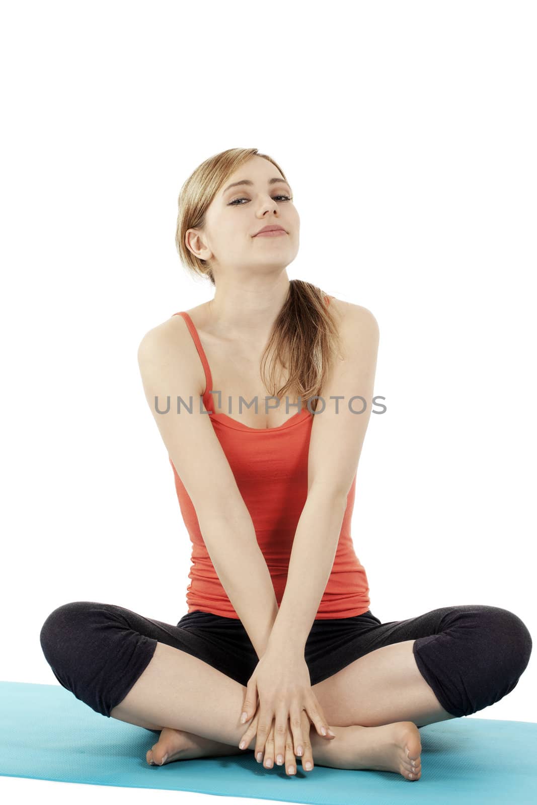 young blonde fitness woman making a break on her mat on white background
