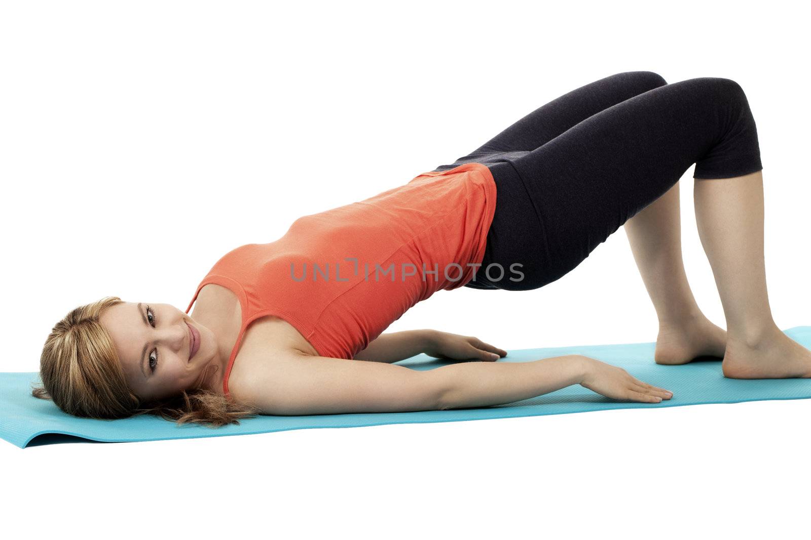 blonde smiling fitness woman exercising on a blue mat on white background