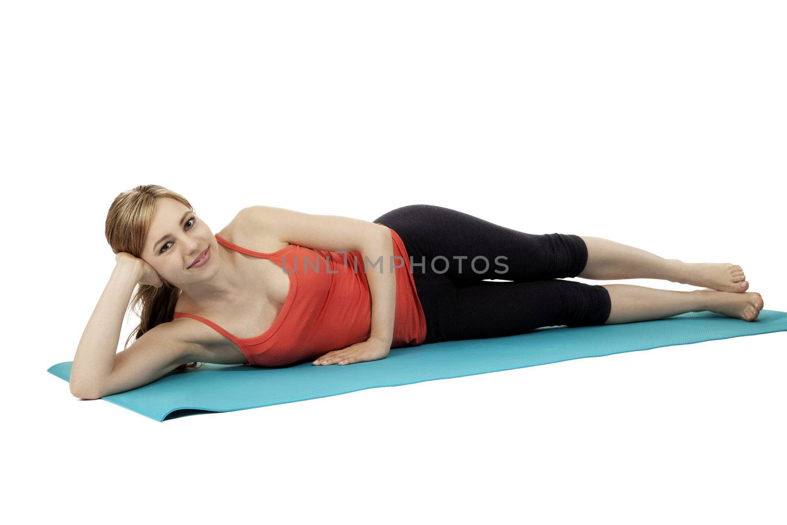 young relaxing fitness woman lie on her blue mat on white background