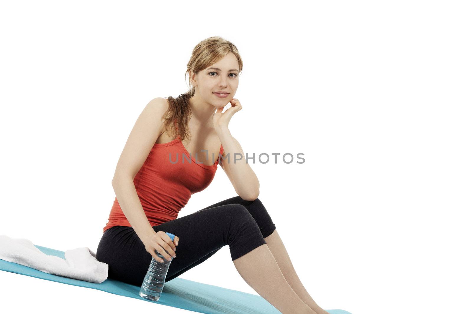 young smiling fitness woman sitting with a bottle of water on white background