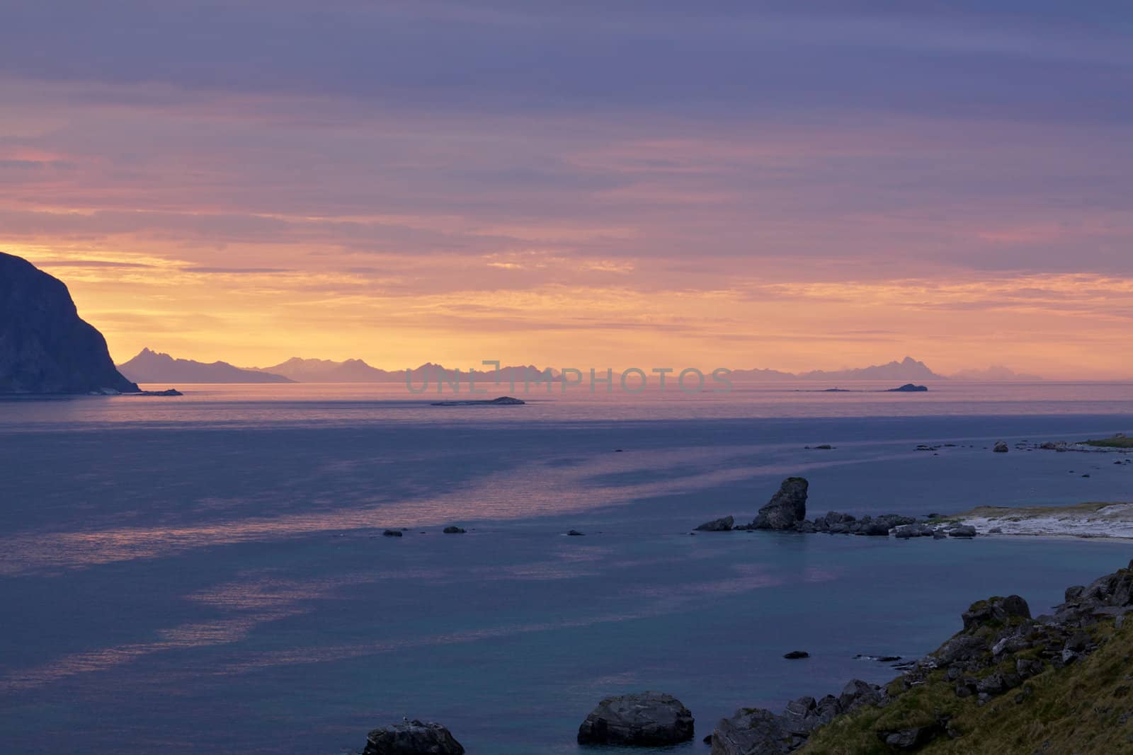 Midnight in Arctic far north on Lofoten islands in Norway with midnight sun creating unusual colors of the sky and sea